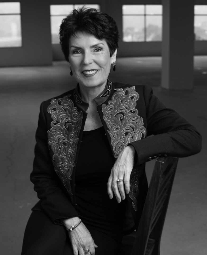 Black and white image of woman sitting on a chair