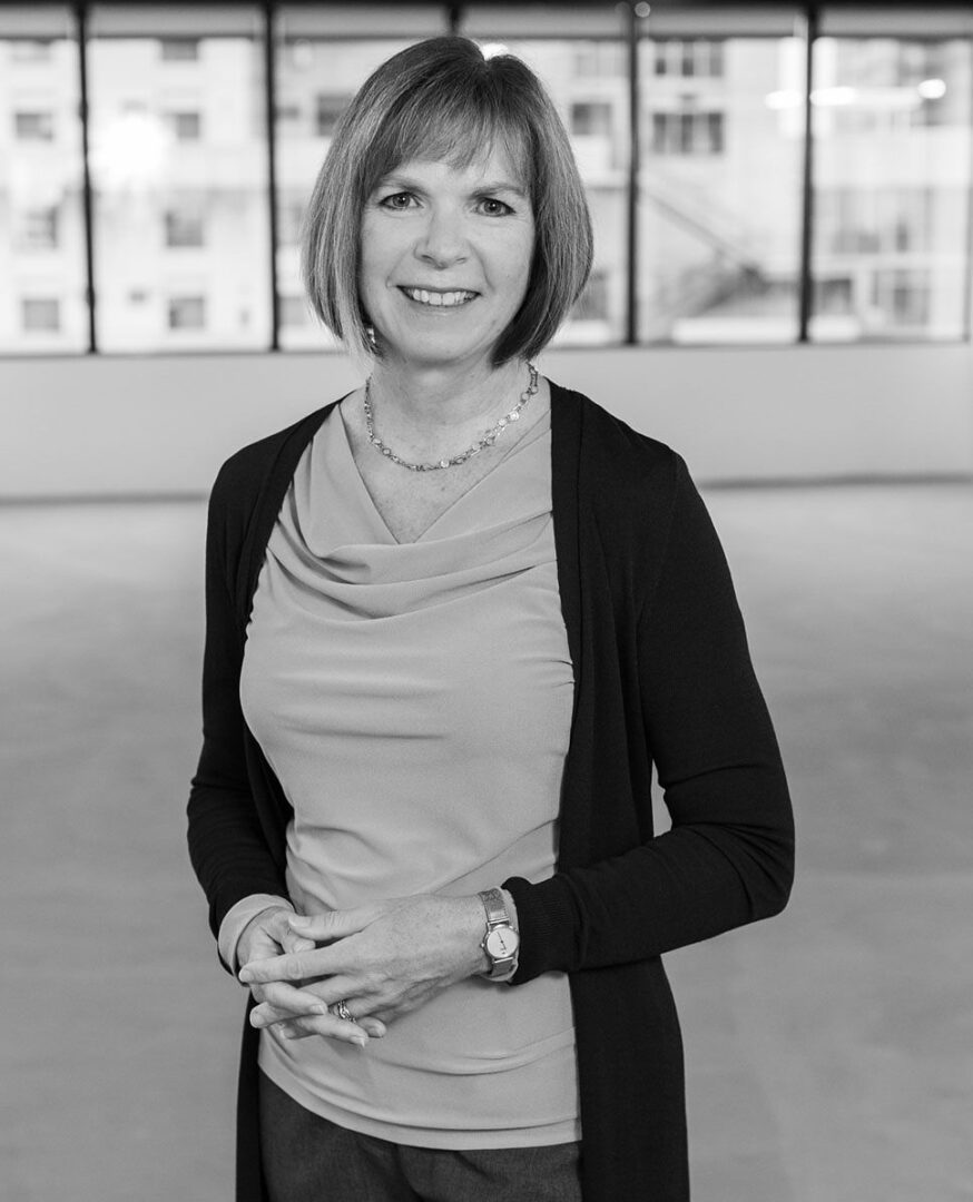 black and white photo of a woman standing inside a building