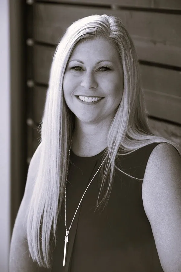 Smiling woman with long hair, black and white.